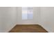 Bright, airy bedroom with wood floors and a large window; simple and clean design at 389 W Fairway Pl, Chandler, AZ 85225