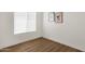 Minimalist bedroom with wood-look vinyl floors, a white wall, and a window with blinds at 389 W Fairway Pl, Chandler, AZ 85225