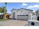 Charming single-Gathering home featuring a two-car garage, white stucco facade, and desert landscaping at 389 W Fairway Pl, Chandler, AZ 85225