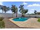 The desert backyard is enhanced by a sparkling blue pool with a waterfall feature, set amongst mature landscaping at 389 W Fairway Pl, Chandler, AZ 85225