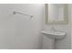 Bathroom features a pedestal sink, framed mirror and wall-mounted towel bar at 43813 W Rio Lobo Dr, Maricopa, AZ 85138