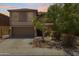 Two-story home boasts a two-car garage and desert landscaping, providing an inviting curb appeal at 43813 W Rio Lobo Dr, Maricopa, AZ 85138