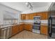 Well-lit kitchen features stainless steel appliances, a tile floor and wood cabinets at 43813 W Rio Lobo Dr, Maricopa, AZ 85138