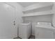Bright laundry room with utility shelving and access door to the exterior at 43813 W Rio Lobo Dr, Maricopa, AZ 85138