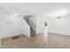 Spacious living room with neutral tile flooring, staircase, and lots of natural light at 43813 W Rio Lobo Dr, Maricopa, AZ 85138