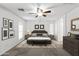 Staged main bedroom with neutral colors, ceiling fan, decorative rug and two windows at 43813 W Rio Lobo Dr, Maricopa, AZ 85138