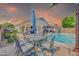 Beautiful backyard with a pool, spa, covered patio, and outdoor dining area, perfect for entertaining at 46068 W Guilder Ave, Maricopa, AZ 85139