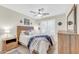 Bedroom features a wood bed frame, ceiling fan, plantation shutters, and wood dresser at 46068 W Guilder Ave, Maricopa, AZ 85139