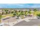 Aerial view showcasing a community park with playgrounds, picnic areas, walking paths, and open green spaces at 46068 W Guilder Ave, Maricopa, AZ 85139