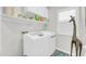 Bright laundry room with white washer and dryer, shelving, giraffe statue, and plantation shutters at 46068 W Guilder Ave, Maricopa, AZ 85139