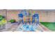 Stylish outdoor bar area with blue seating, decorative wall art, and a vibrant area rug on a brick patio at 46068 W Guilder Ave, Maricopa, AZ 85139