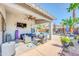 Relaxing covered patio with comfortable seating, ceiling fan, outdoor TV, and view of the refreshing pool at 46068 W Guilder Ave, Maricopa, AZ 85139