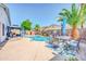 Outdoor oasis showcasing a sparkling pool, covered patio with grill, and seating area amid lush landscaping at 46068 W Guilder Ave, Maricopa, AZ 85139