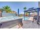 Backyard with a pool, gazebo, and hot tub. surrounded by palm trees and brick pavers at 46068 W Guilder Ave, Maricopa, AZ 85139