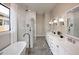 This bathroom features double sinks, a large bathtub, and a glass shower, creating a luxurious and functional space at 490 E Aurora Dr, San Tan Valley, AZ 85140