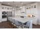 A bright white kitchen features a large island with seating, pendant lighting and modern stainless steel appliances at 490 E Aurora Dr, San Tan Valley, AZ 85140