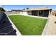 Spacious backyard featuring lush synthetic grass, gravel accents, and a covered patio, perfect for outdoor enjoyment at 514 N 74Th St, Scottsdale, AZ 85257
