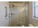 Updated bathroom with a glass-enclosed shower and light-colored tiled walls and flooring at 5735 E Mcdowell Rd # 108, Mesa, AZ 85215