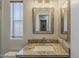 Bathroom vanity with a neutral granite countertop, a square sink, and a large framed mirror at 5735 E Mcdowell Rd # 108, Mesa, AZ 85215