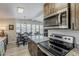 Open kitchen with stainless appliances flows into bright dining room and seating for six at 5735 E Mcdowell Rd # 108, Mesa, AZ 85215