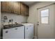 Laundry room area featuring a washer, a dryer, and overhead cabinets at 5735 E Mcdowell Rd # 108, Mesa, AZ 85215