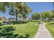 Beautiful park area with manicured lawns, trees, and walking path at 5735 E Mcdowell Rd # 108, Mesa, AZ 85215