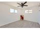 The bright bedroom has dual windows, a ceiling fan, and modern gray wood-look tile flooring at 5827 N 22Nd Dr, Phoenix, AZ 85015