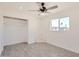 Bright bedroom features a ceiling fan, closet, and a modern gray wood-look tile flooring at 5827 N 22Nd Dr, Phoenix, AZ 85015