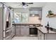 Well-lit kitchen featuring stainless-steel appliances, gray cabinetry, tile backsplash and ample counter space at 5827 N 22Nd Dr, Phoenix, AZ 85015