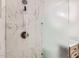 A close up of the newly renovated marble shower with new fixtures and a frosted glass divider at 5827 N 22Nd Dr, Phoenix, AZ 85015