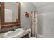 Bathroom with a shower-tub combo, neutral walls, and a sink with a wooden-framed mirror at 650 N Hawes Rd # 2819, Mesa, AZ 85207