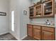 Classic butler pantry featuring wooden cabinetry, granite countertops, and glass-front display cabinets at 650 N Hawes Rd # 2819, Mesa, AZ 85207