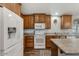 Modern kitchen featuring wood cabinets, white appliances, and an island, perfect for cooking and dining at 650 N Hawes Rd # 2819, Mesa, AZ 85207
