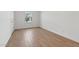 Simple, bright bedroom with wood-look flooring and a view from the window at 7421 S 76Th Ln, Laveen, AZ 85339