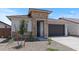 View of a one-story home with a stone facade, neutral paint, and a spacious two-car garage at 7421 S 76Th Ln, Laveen, AZ 85339