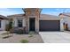 Stylish single-Gathering home featuring stone accents and a gray garage door for a modern, appealing facade at 7421 S 76Th Ln, Laveen, AZ 85339
