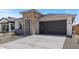 Front view of a charming single-Gathering home with a gray garage door and desert landscaping at 7421 S 76Th Ln, Laveen, AZ 85339