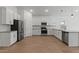 Bright, modern kitchen with white cabinets, stainless steel appliances, and wood-look flooring at 7421 S 76Th Ln, Laveen, AZ 85339