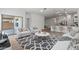 Bright, open-concept living room featuring stylish furniture and wood-look flooring, flowing into the kitchen at 7421 S 76Th Ln, Laveen, AZ 85339