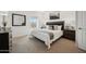 This bedroom features carpet floors, a luxurious bed, stylish decor, and a view at 7454 S 75Th Dr, Laveen, AZ 85339