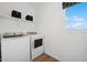 Bright laundry room featuring modern washer and dryer, window, and white shelving at 7454 S 75Th Dr, Laveen, AZ 85339