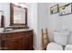 Cozy powder room with granite countertop vanity and decorative accent ladder next to toilet at 7835 E Cannon Dr, Scottsdale, AZ 85258