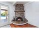 Close-up of a charming stone fireplace in the living room with views to the pool at 7835 E Cannon Dr, Scottsdale, AZ 85258