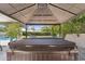 Covered hot tub with view of backyard featuring mature trees, patio furniture, and manicured lawn at 7835 E Cannon Dr, Scottsdale, AZ 85258