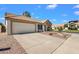 Single-story home with a two-car garage, desert landscaping, and a long driveway at 823 W Kyle Ct, Gilbert, AZ 85233
