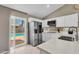 Bright kitchen features stainless steel appliances, white cabinets, quartz countertops, and a view to the pool at 823 W Kyle Ct, Gilbert, AZ 85233