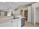 Bright kitchen features white cabinets, stainless steel appliances, and quartz countertops, open to the living area at 823 W Kyle Ct, Gilbert, AZ 85233