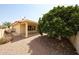 Private backyard with mature trees providing shade, gravel ground cover, and covered patio at 8303 E Monterey Ave, Mesa, AZ 85209