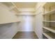 Walk-in closet with white walls, wood floors, and shelving for optimal storage at 8303 E Monterey Ave, Mesa, AZ 85209