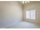 Bright bedroom features neutral carpet, tall ceilings, and a window with blinds at 9412 S Palm Dr, Tempe, AZ 85284